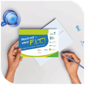 Hände halten eine bunte Postkarte mit der Aufschrift ‚Mach mit – werd F.I.T.!‘ über einem hellen Schreibtisch. Auf der Karte stehen die Themen Fit in Digital, Ideen im Handwerk und Tradition in der Küche sowie die Logos der Projektpartner.